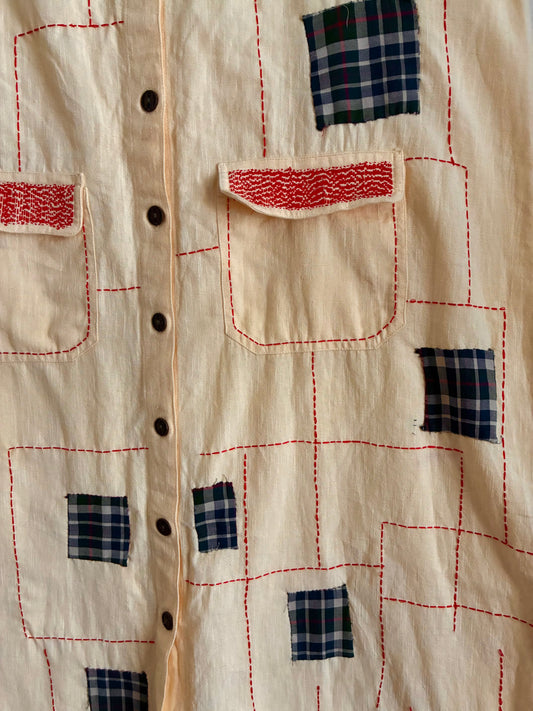 An upcycled dungaree featuring appliqué and running stitches.