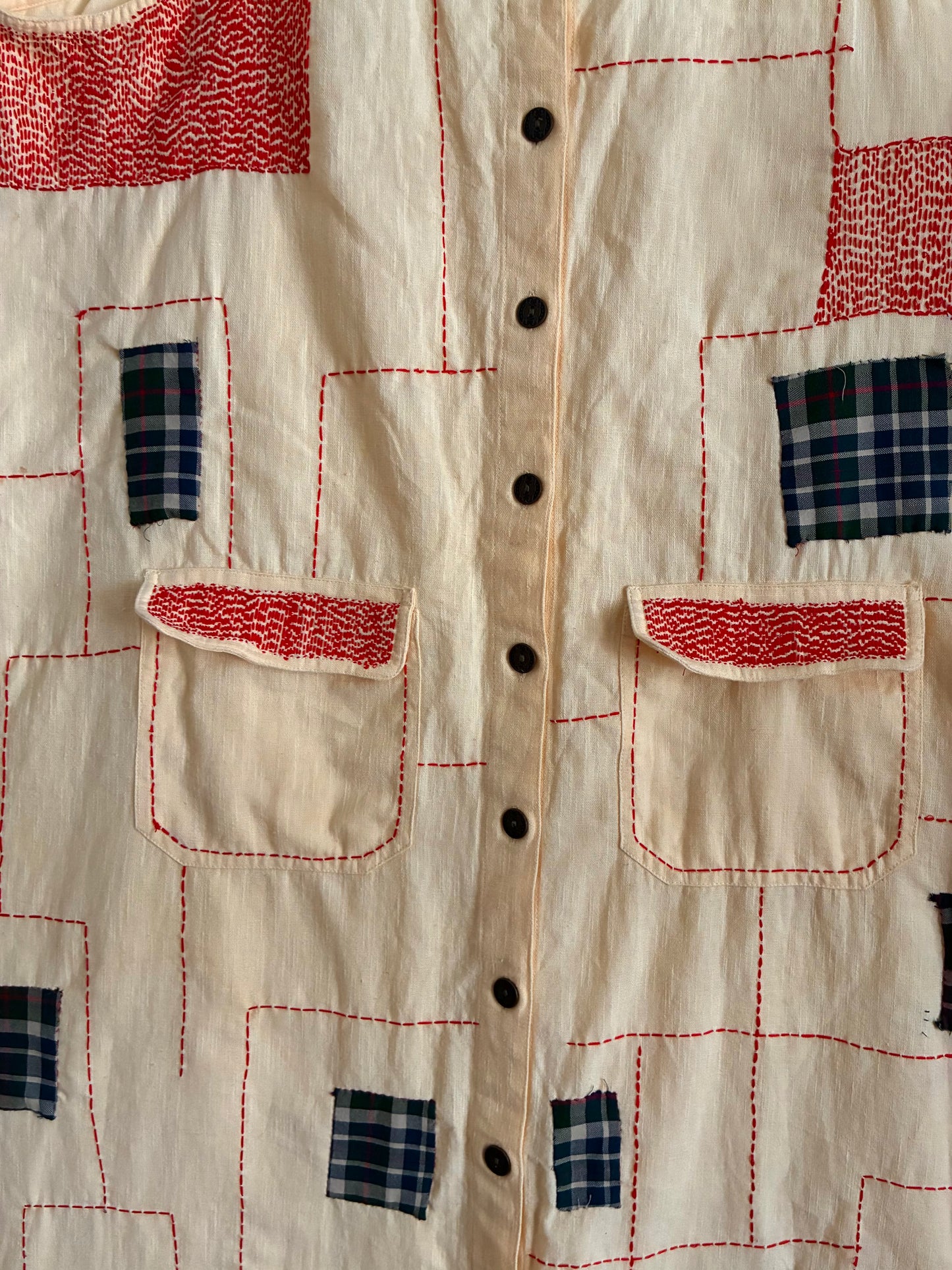 An upcycled dungaree featuring appliqué and running stitches.