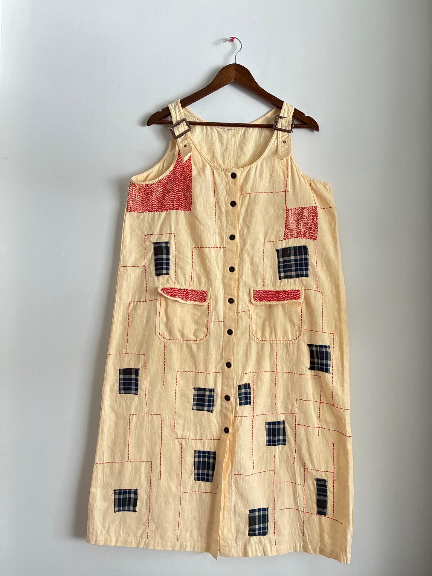 An upcycled dungaree featuring appliqué and running stitches.